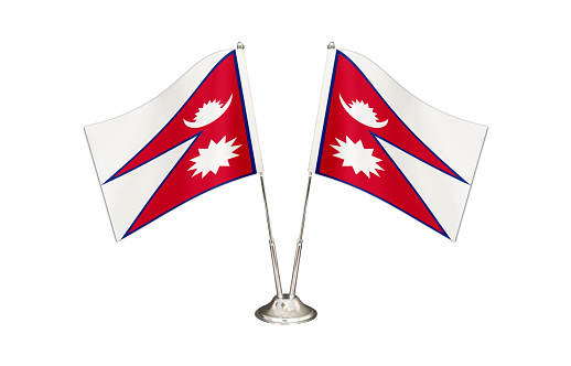 Nepal table flag isolated on white ground. Two flag poles with flags and Nepal flag on the table.