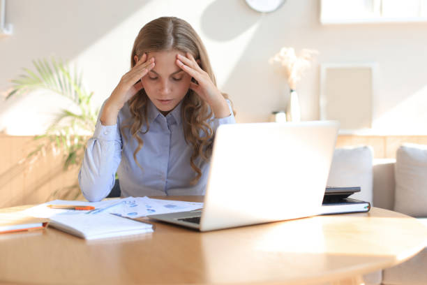 istock Frustrated business woman looking exhausted while sitting at her working place. 1287031817