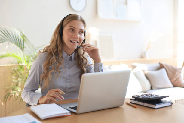 istock Freelance operator talking with headsets and consulting clients from home office. 1287031872