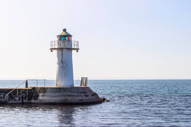 istock Lighthouse on a pier with the water horizon 1287031916