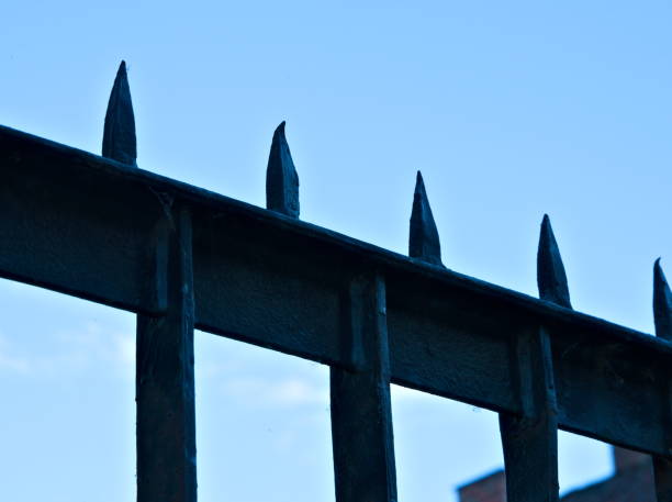 istock Spiked steel security fence, close-up 1287032648