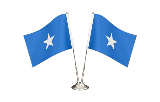 Somalia  table flag isolated on white ground. Two flag poles with flags and Somalia flag on the table.