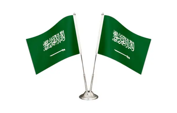 Saudi Arabia table flag isolated on white ground. Two flag poles with flags and Saudi Arabia flag on the table.