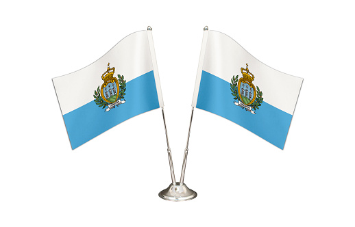 San Marino table flag isolated on white ground. Two flag poles with flags and San Marino  flag on the table.
