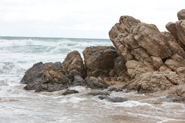 Rock formation and waves at beach.Rugged and rocky coastal scenic with rough surf.