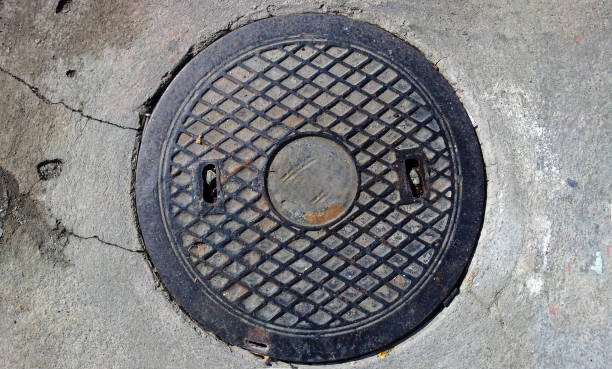 istock Steel sewer manhole on pavement. Sewer cover 1287034008