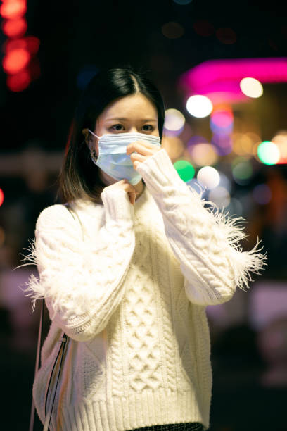 istock Asian woman wearing surgical mask 1287034143