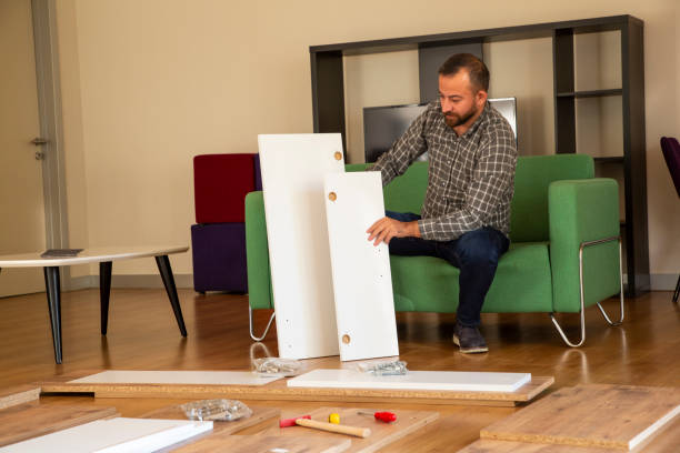 istock Man surrounded by unassembled furniture 1287035473