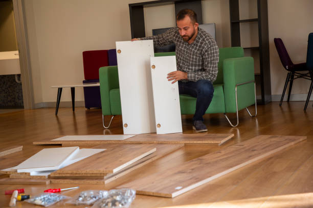istock Man surrounded by unassembled furniture 1287036082