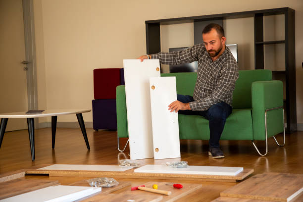 istock Man surrounded by unassembled furniture 1287036475