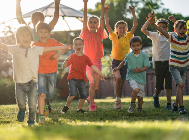 istock Group of kids running in public park 1287036656