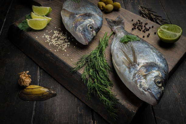 istock Fresh raw dorado fish on cutting board. Culinary seafood background 1287037388