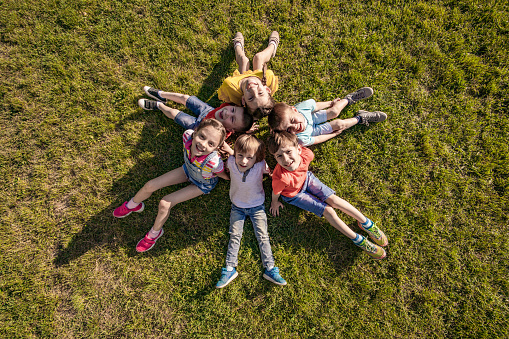 High angle view of a group of kids sitting on the grass