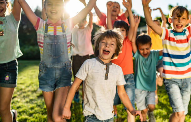 istock Kids with arms raised running in nature 1287038808