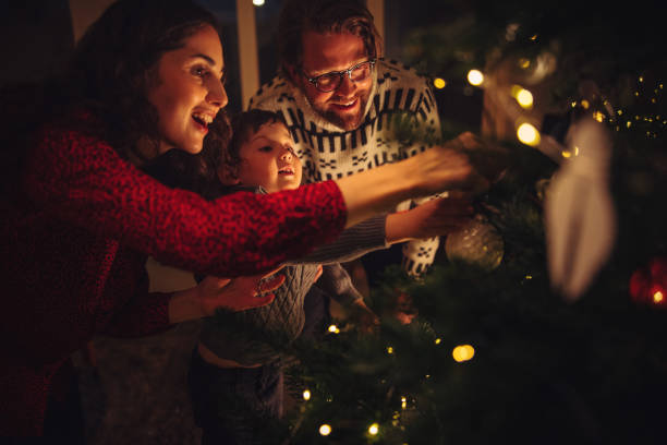 istock Family decorating Christmas tree at home 1287040242
