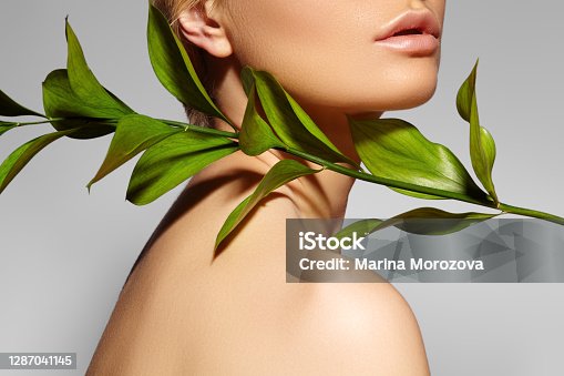 istock Beautiful woman applies Organic Cosmetic. Spa and Wellness. Model with Clean Skin. Healthcare. Picture with leaf 1287041145