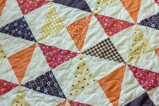 Quilt. A fragment of a patchwork quilt as a background. Colored patchwork quilt.
