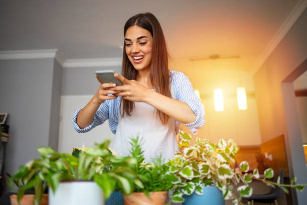 istock Beautiful young woman caring for her plants 1287042959