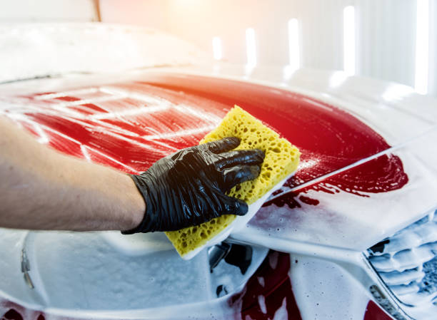 istock Worker washing red car with sponge on a car wash 1287044335