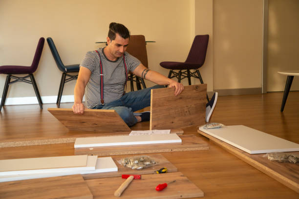 istock Man surrounded by unassembled furniture 1287045597