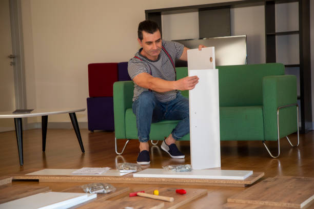 istock Man surrounded by unassembled furniture 1287045639