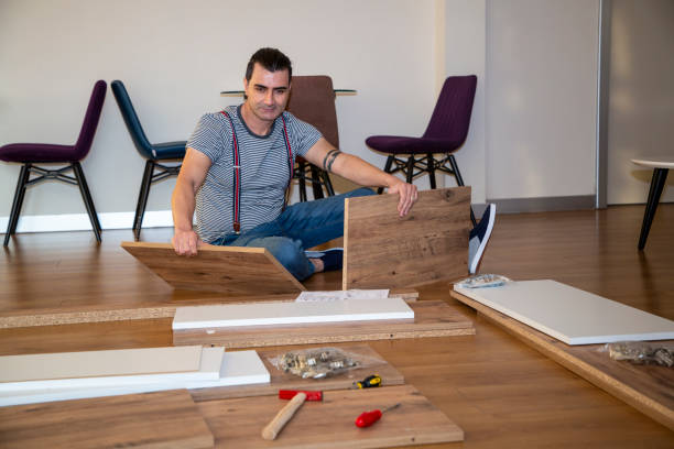 istock Man surrounded by unassembled furniture 1287045905