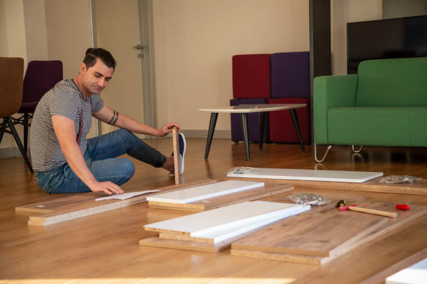 istock Man surrounded by unassembled furniture 1287045909
