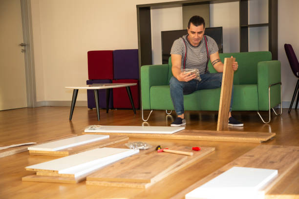 istock Man surrounded by unassembled furniture 1287046032