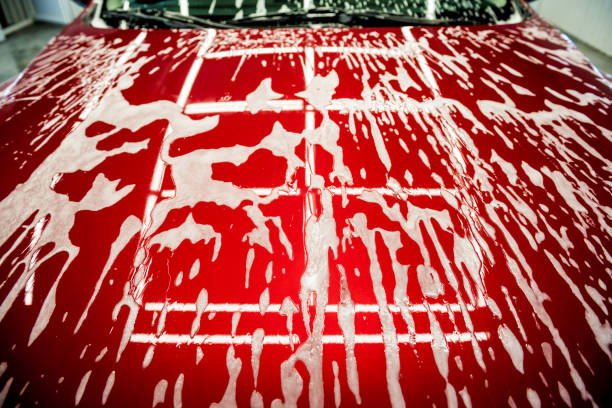 istock Washing red car with active foam at car wash service. 1287047292