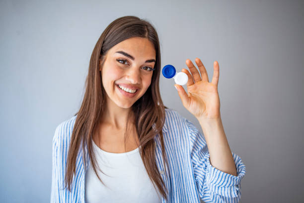istock Woman  holding container for transparent soft contact lens. 1287047587