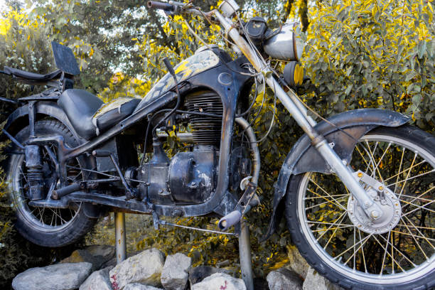 istock Old retro motorcycle parked by a green hedge. Front view. 1287049256