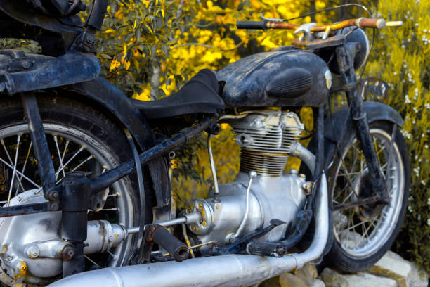 istock Old retro motorcycle parked by a green hedge. Back view. 1287049271