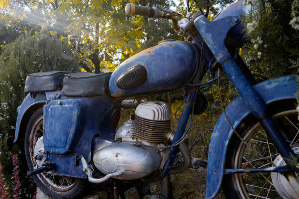 istock Old retro motorcycle parked by a green hedge. Front view. 1287049349