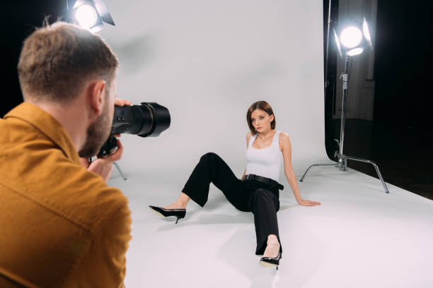 istock Selective focus of beautiful model working with photographer in photo studio 1287050517