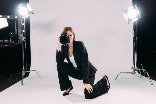 istock Stylish model taking photo with digital camera in photo studio 1287050560