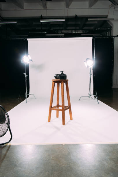 istock Digital camera on wooden chair in photo studio 1287050567