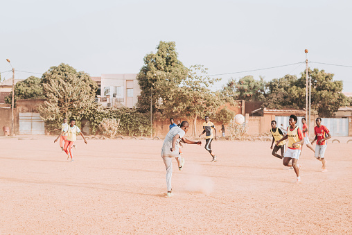 Ouagadougou, Burkina Faso, December 2017. In the districts of the capital of the sub-Saharan state there are many football fields where you can watch amateur football matches every day. In this image you can see some people playing football in one of the clay football fields of Ouagadougou.