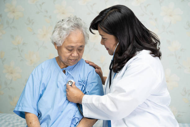 istock Doctor using stethoscope to checking the patient sit down on a bed in the hospital ward, healthy strong medical concept 1287052410
