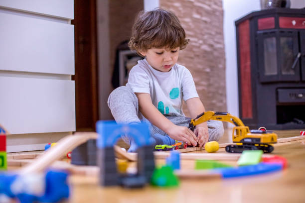 istock Beautiful little boy playing with a railroad train toy. 1287053300