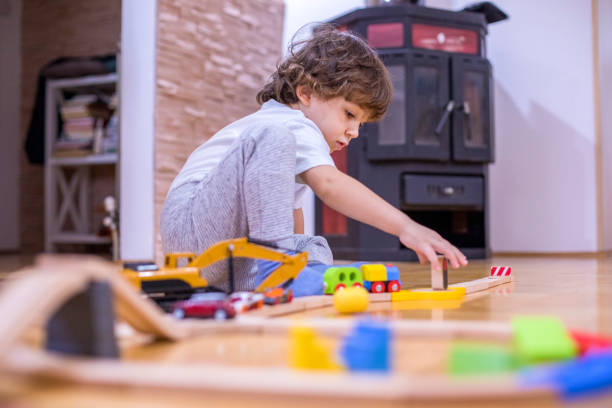 istock Beautiful little boy playing with a railroad train toy. 1287053301