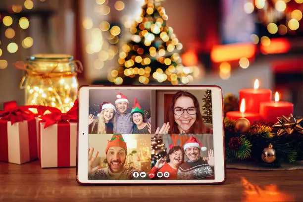 Christmas video call with the family. Concept of families in quarantine during Christmas because of the coronavirus. Xmas still life with a tablet in a cozy room