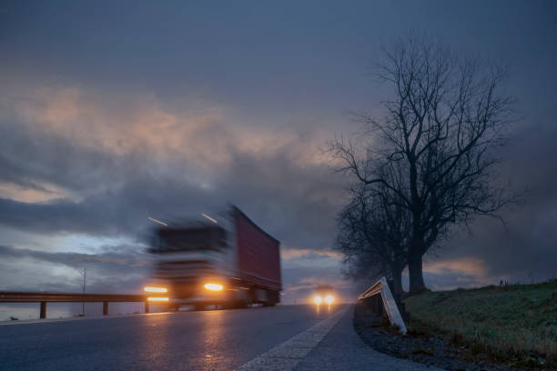 istock Lighted cars at dusk on  main road 1287056738