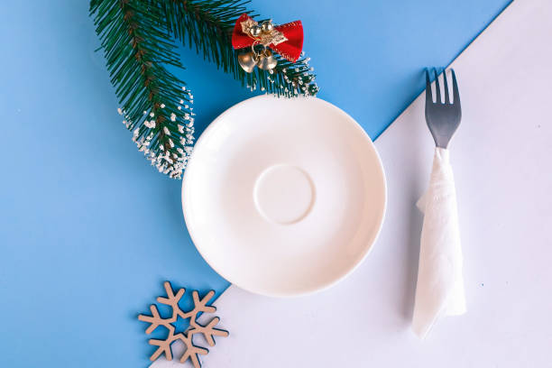 istock Empty plate and Christmas decorations on color geometric background, copy space for the text, minimal concept 1287058623
