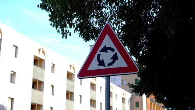 Triangular traffic sign indicating Roundabout car movement
