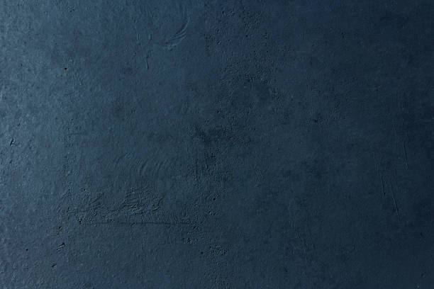 istock Dark blue concrete wall with light gradient and free space for text and design 1287058926