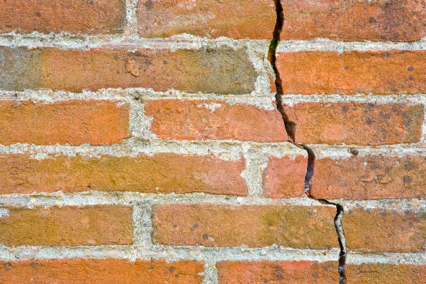 istock Old wall built with bricks cracked and damaged due to structural failure 1287059684