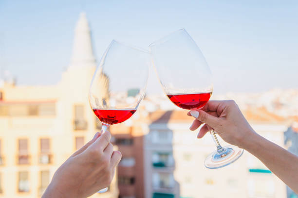 istock Two glasses with red wine in female hands against the sky. 1287063744