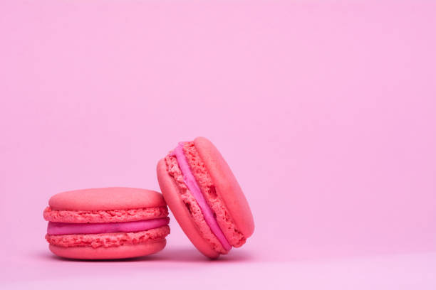 istock Two pink macaron cookies on a pink background. 1287065247