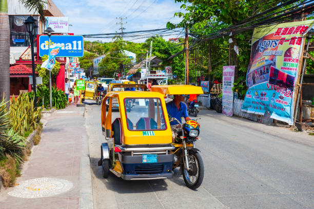 Tricycle is a popular transport in Philippines BORACAY, PHILIPPINES - MARCH 04, 2013: Tricycle at the main street in Boracay island. Tricycle is a very popular public taxi transport in Philippines. philippines tricycle stock pictures, royalty-free photos & images