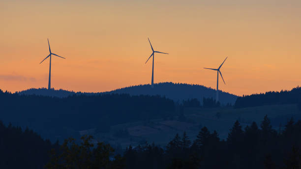 istock wind turbines on mountain range against sunset sky 1287068609